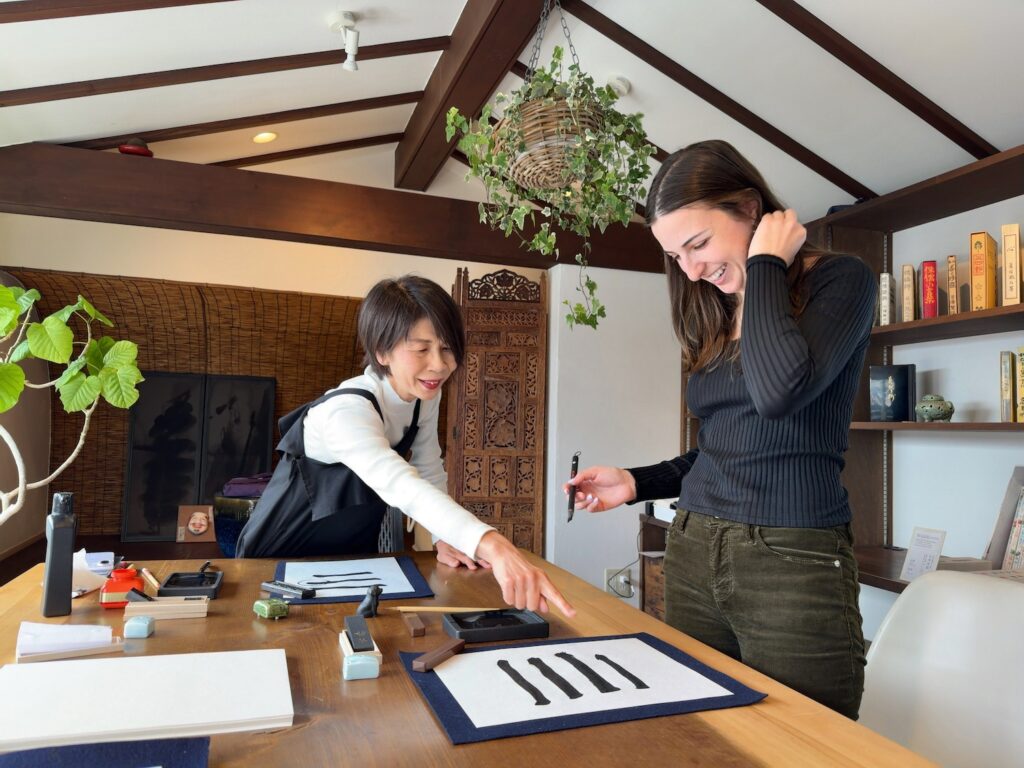 Guest from the United States practicing basic brush strokes under instructor guidance at Atelier & Gallery Ichirin in Kamakura