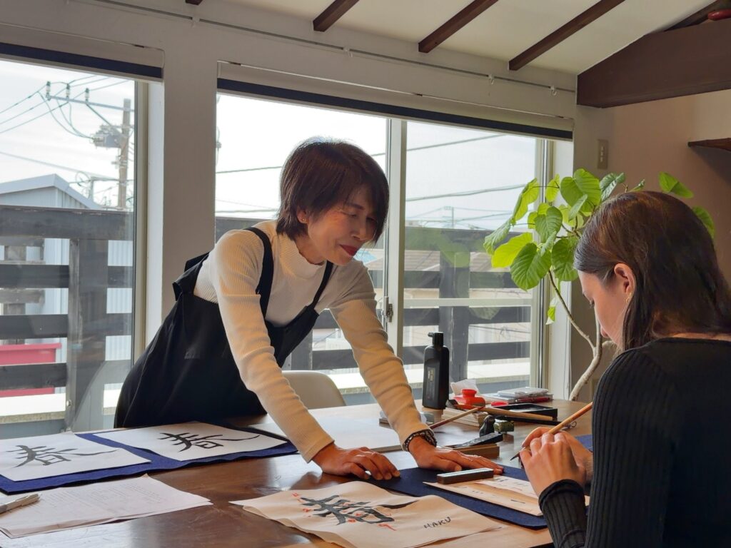 Guest from the United States completing her final Japanese calligraphy artwork on washi paper at Atelier & Gallery Ichirin in Kamakura