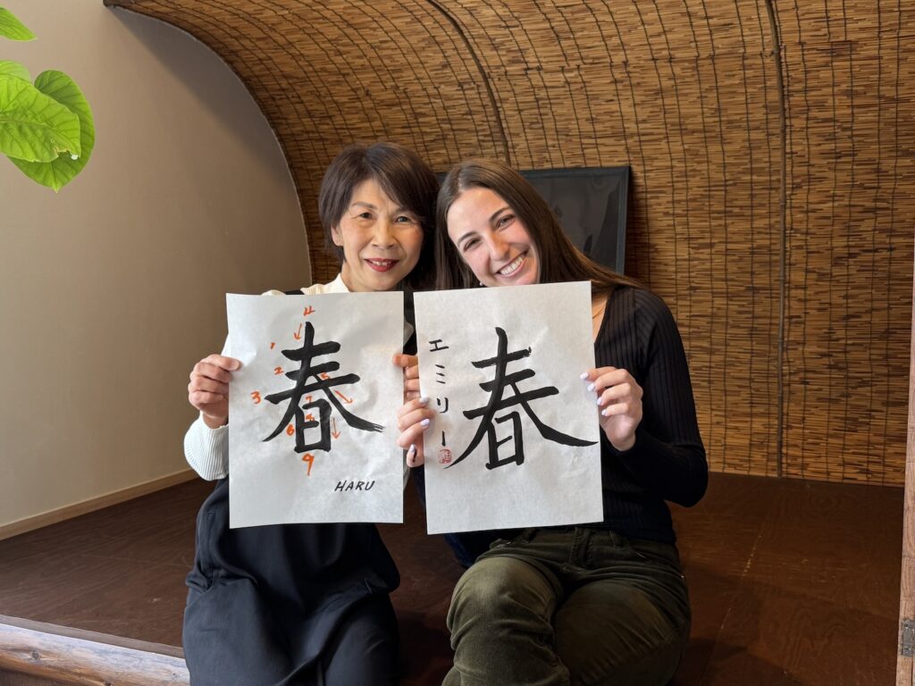 Guest from the United States holding her calligraphy artwork with the instructor at Atelier & Gallery Ichirin in Kamakura
