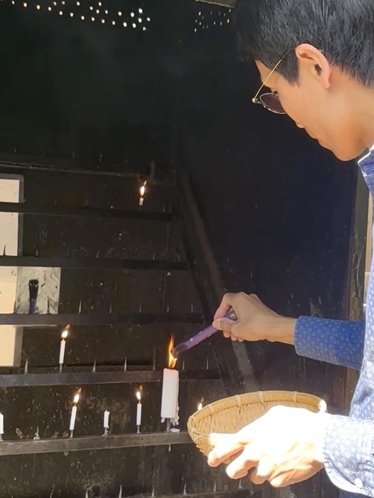 Lighting a candle and incense at Zeniarai Benzaiten Shrine