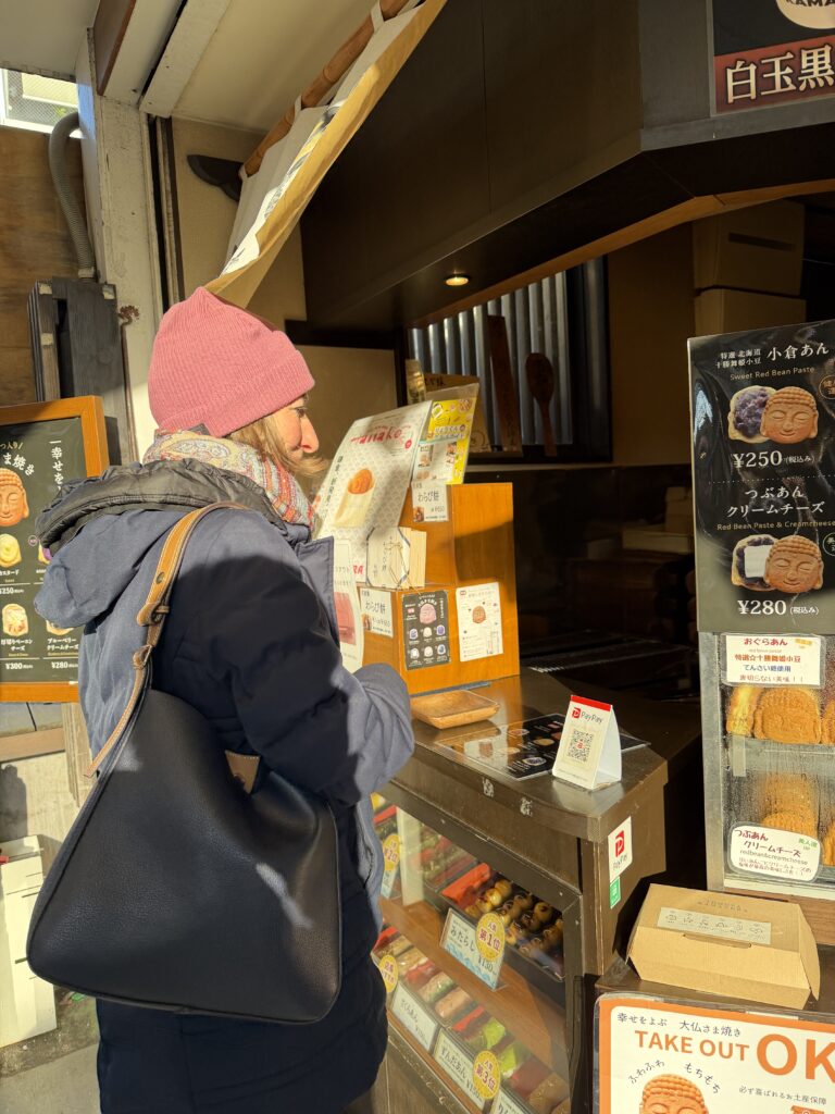 Guest selecting Buddha-shaped ningyo-yaki at a sweets shop on Komachi Street in Kamakura