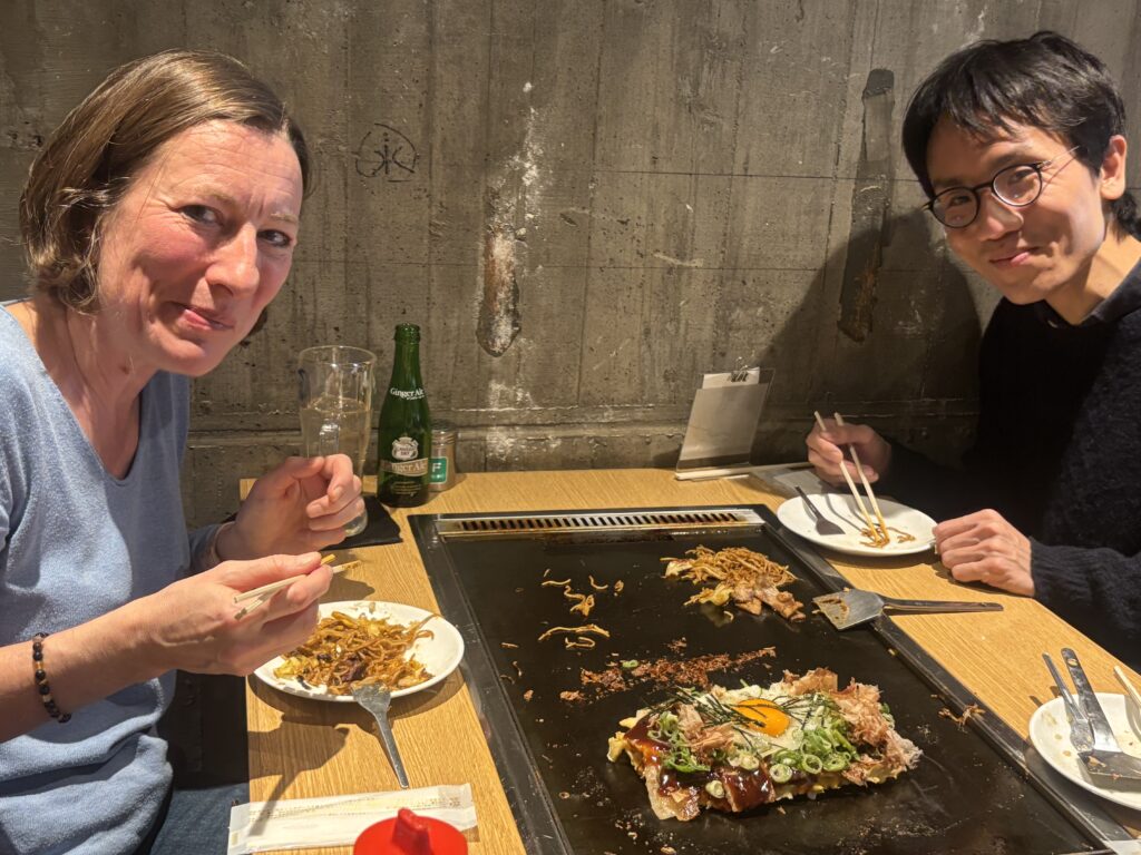 Guide and guests enjoying monja and yakisoba around a hotplate at a Kamakura monja restaurant